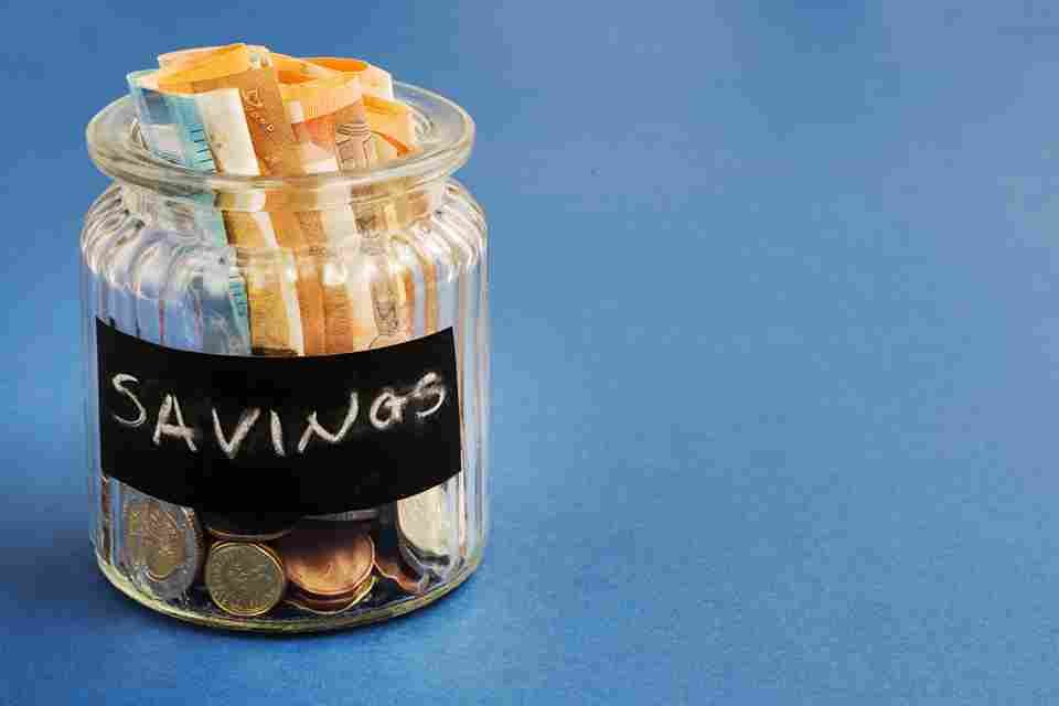 saving-bottle with-euro-notes-coins-blue-background